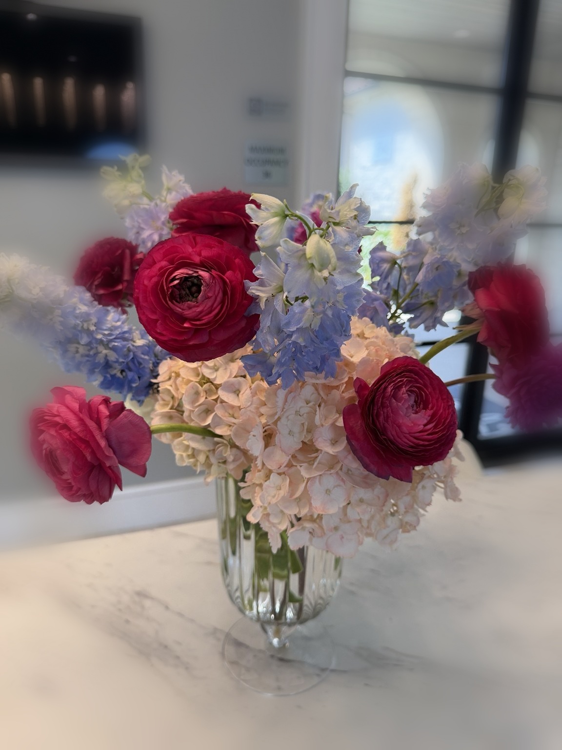 Bright pink, blue and blush event floral arrangement with ranunculus and delphinium by Petite Petal