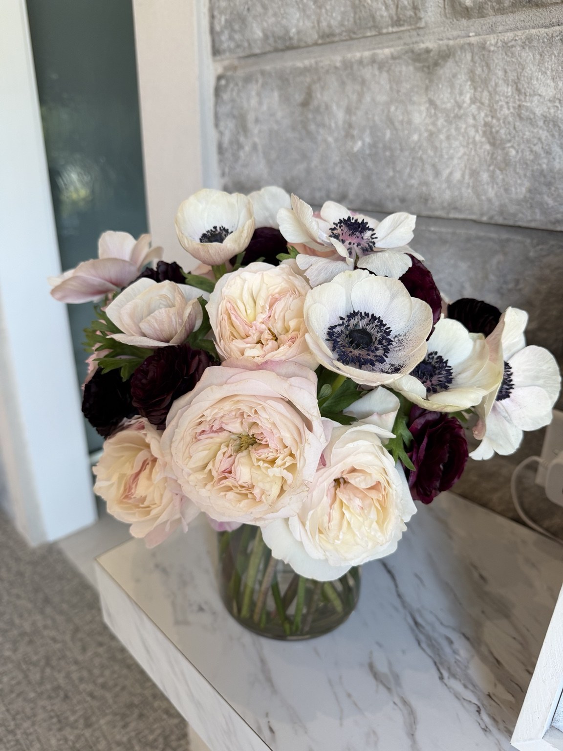 Classic pastel floral arrangement with blush roses, white flowers and burgundy accents by Petite Petal