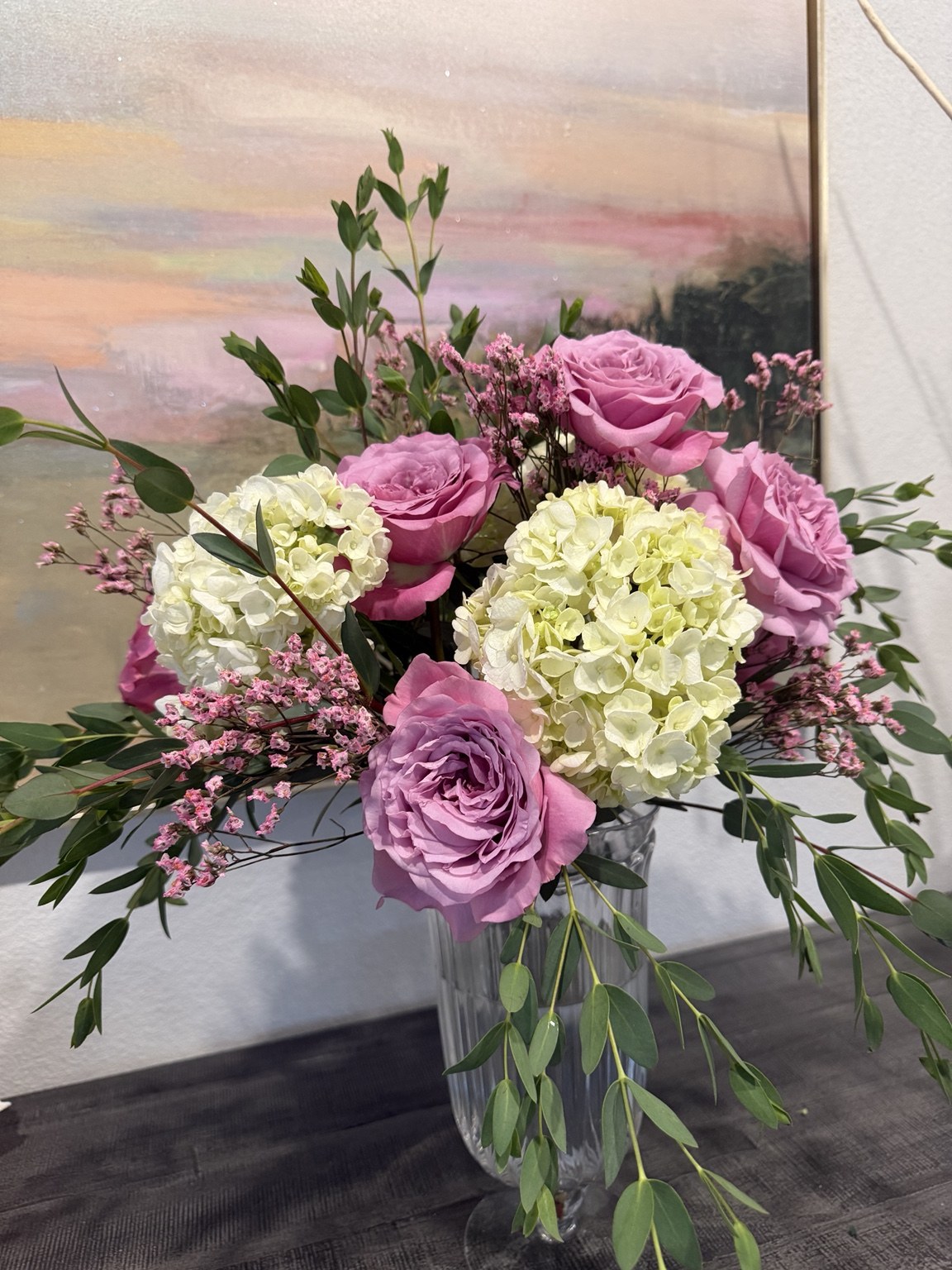 Lush pink and lilac floral arrangement with hydrangea, roses and greenery by Petite Petal