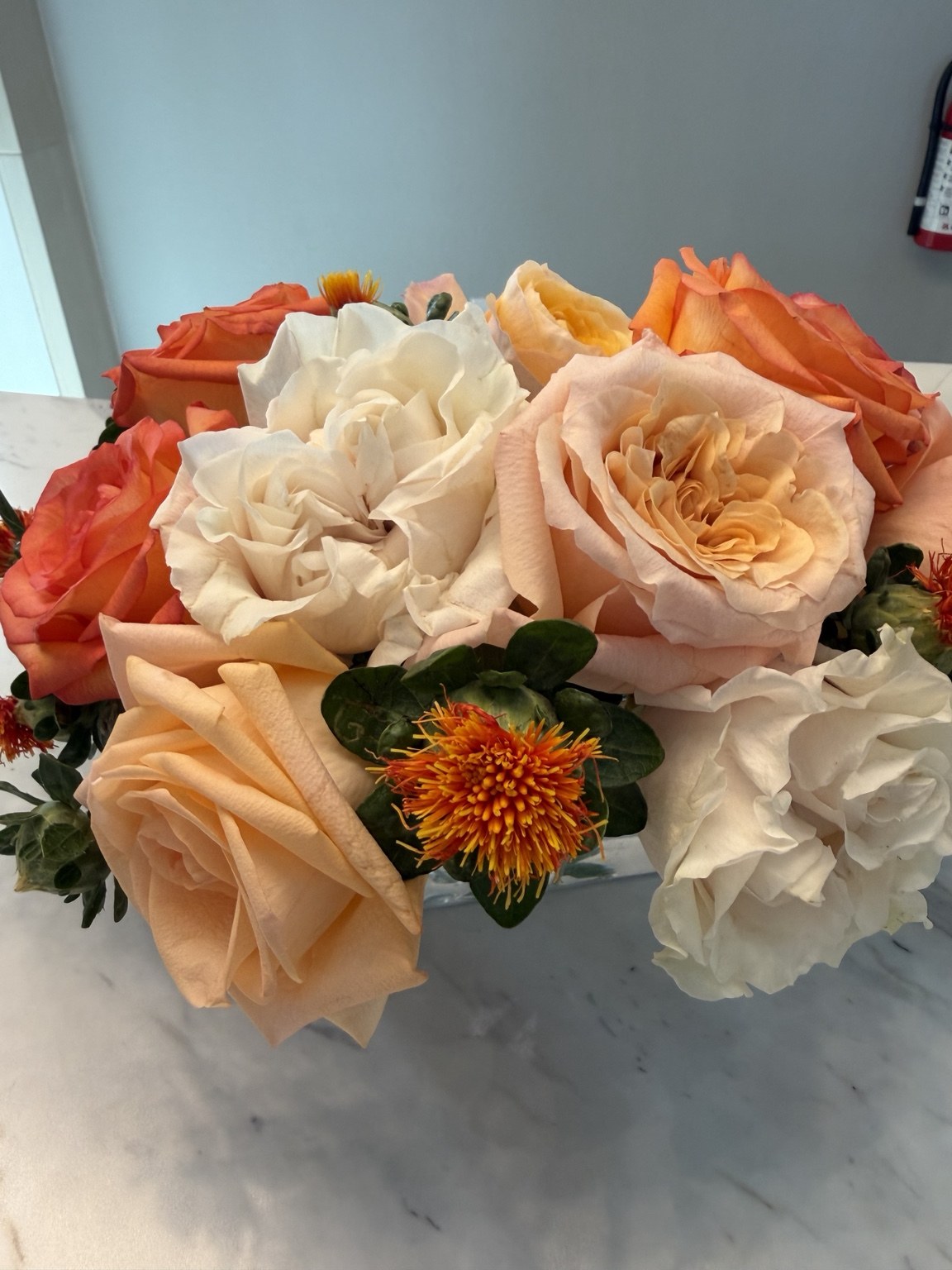 Peach rose and white floral arrangement with a sculptural garden-inspired design by Petite Petal