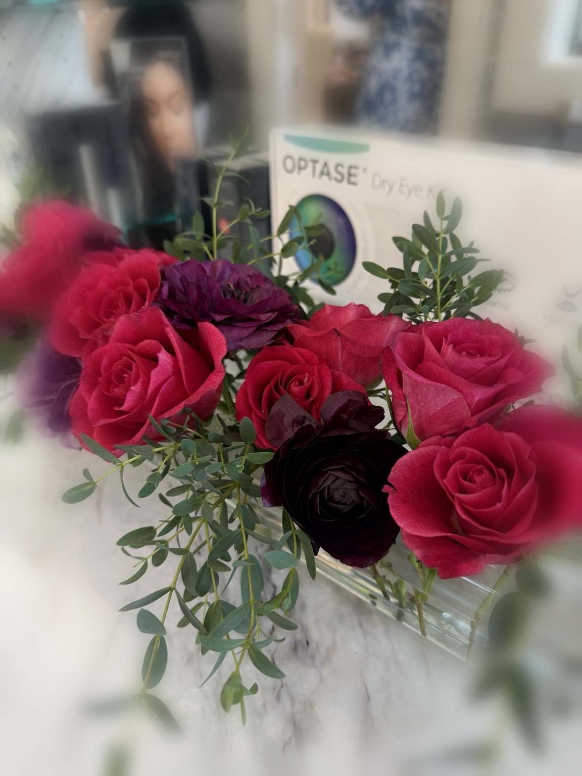 Rich red and burgundy rose floral arrangement with greenery by Petite Petal